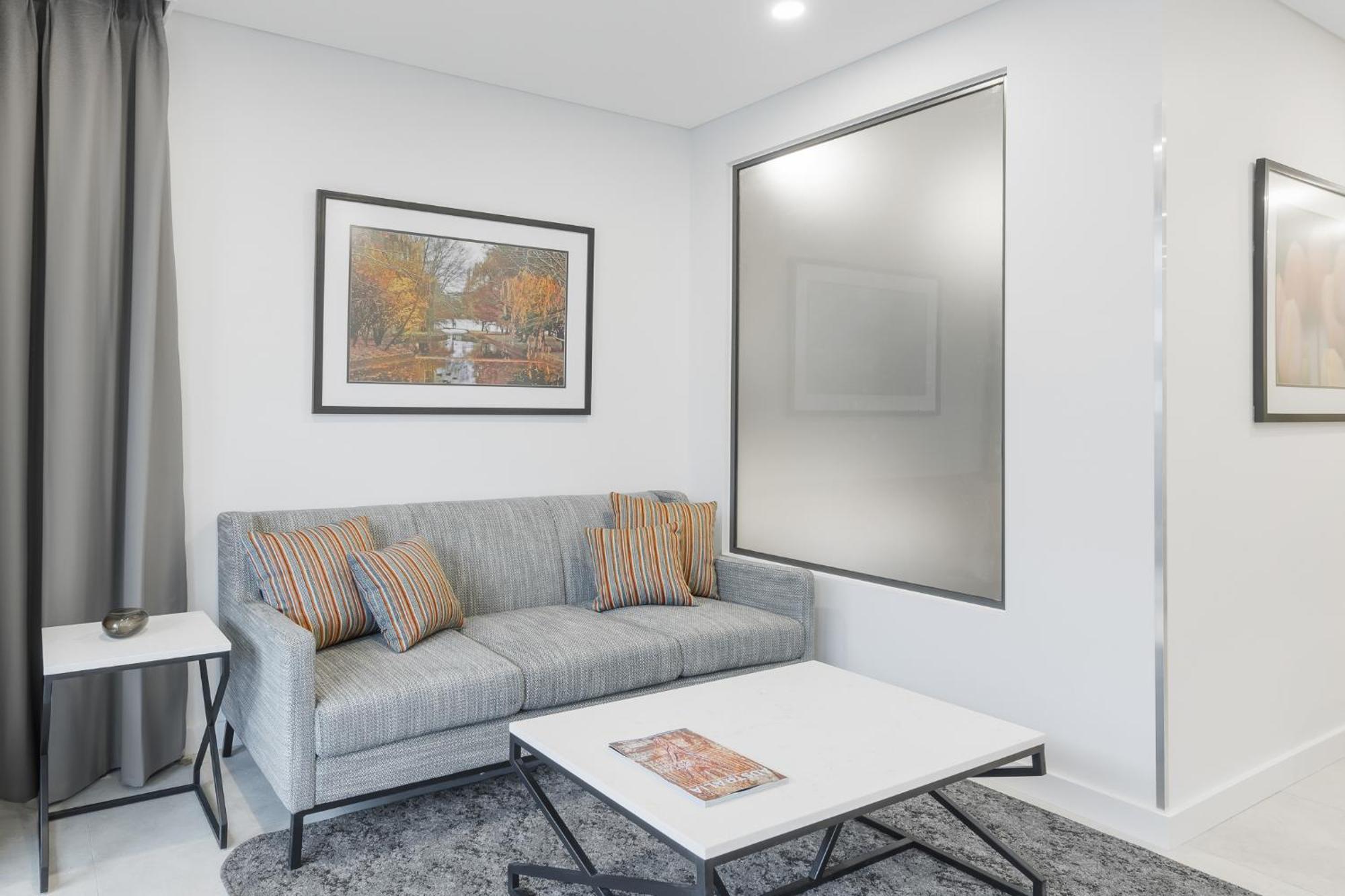 Meriton Suites Канберра Экстерьер фото A living room with a sofa